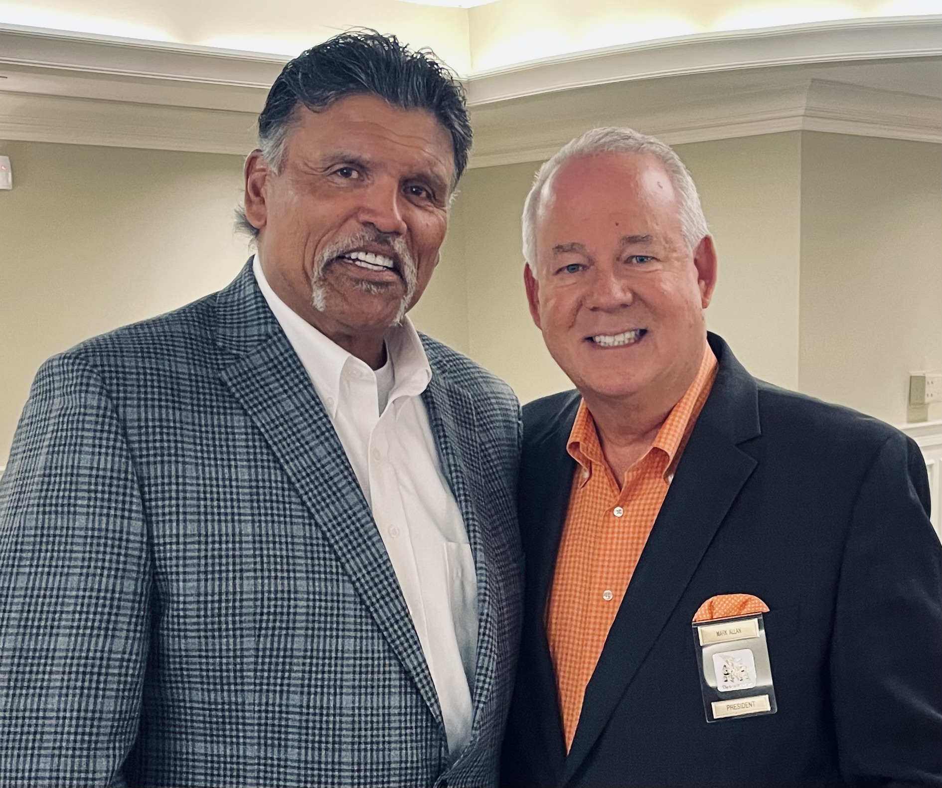 Two men in suits posing for a picture.