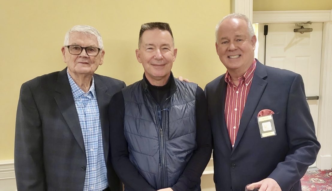 Three men standing next to each other in a room.